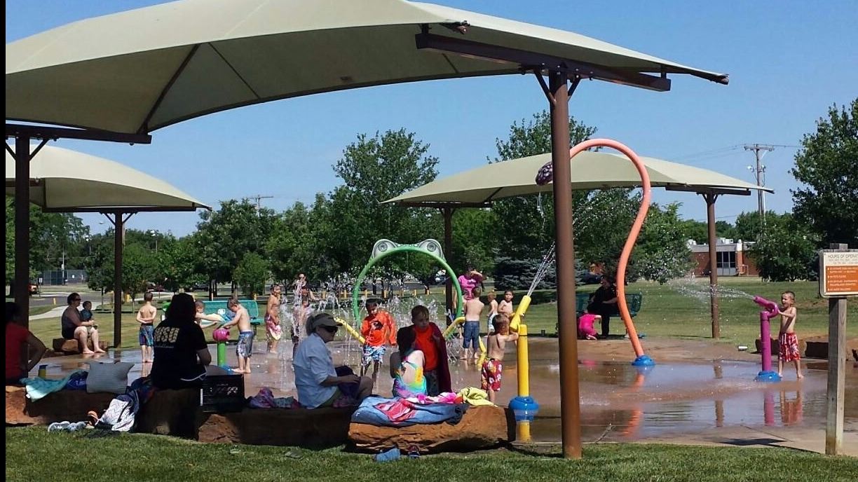 People seated under umbrellas in a park